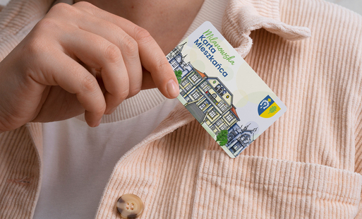 ręka trzymająca plastikową kartę mieszkańca