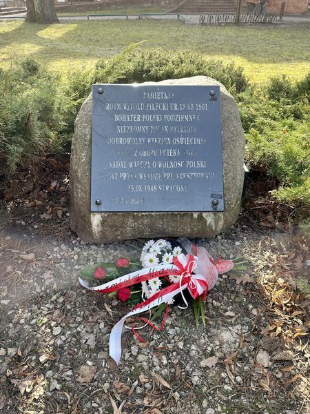 Pomnik rotmistrza Pileckiego, a na nim złożona wiązanka z biało-czerwonych kwiatów