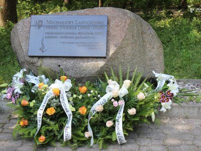Kwiaty złożone pod tablicą upamiętniającą Michała Lasockiego